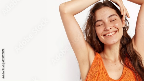 A beautiful woman smiling and holding her arms up, showing off the natural beauty of underarm skin with visible armpit hair on a white background