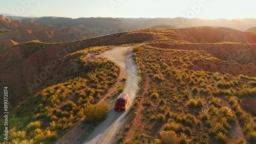 Red camper van driving through the Gorafe desert in Andalusia, Spain photo