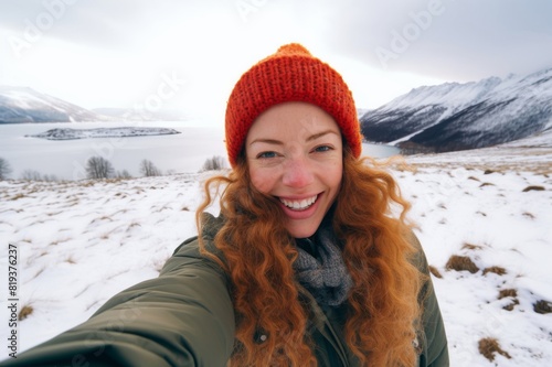 woman taking a selfie in front of beautiful winter landscape