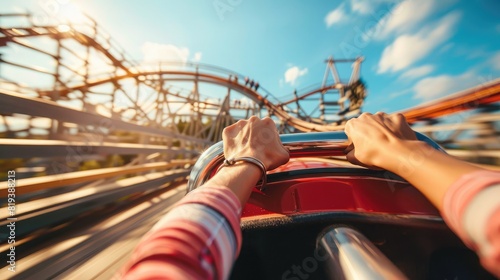 Hand gripping the safety bar on a roller coaster ride with the tracks and sky visible photo