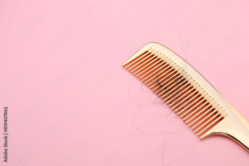 Comb with lost hair on pink background, space for text Comb with lost hair on pink background, space for text