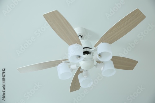 Ceiling fan with lamps indoors, low angle view