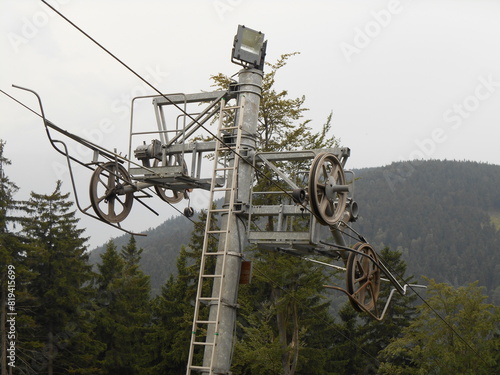 Metal pole and mechanism supporting the ropes of a chairlift in the mountains. photo