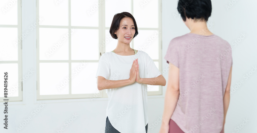 Obraz premium スポーツジムでヨガをするミドル女性