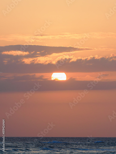 Beautiful Sunset, Big Sun in Clouds above Atlantic Ocean.