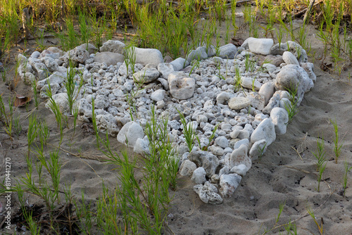 Heart shaped stones on the sandy beach.