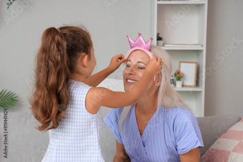 Little girl putting crown o...