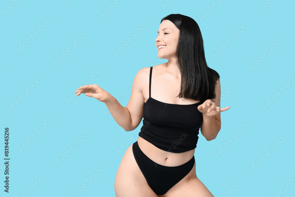 Body positive young woman in underwear on blue background Body positive young woman in underwear on blue background