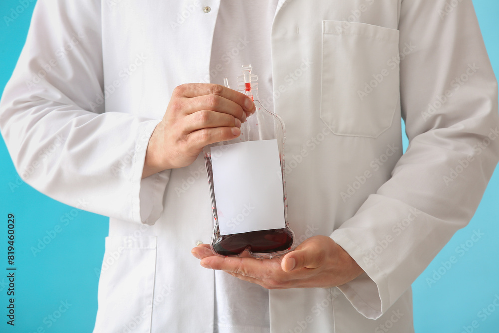 Doctor with blood pack on blue background. Blood donation concept Doctor with blood pack on blue background. Blood donation concept