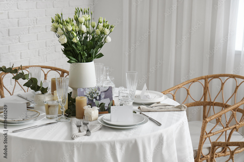 Beautiful table setting with eustoma flowers and candles for wedding celebration in room Beautiful table setting with eustoma flowers and candles for wedding celebration in room