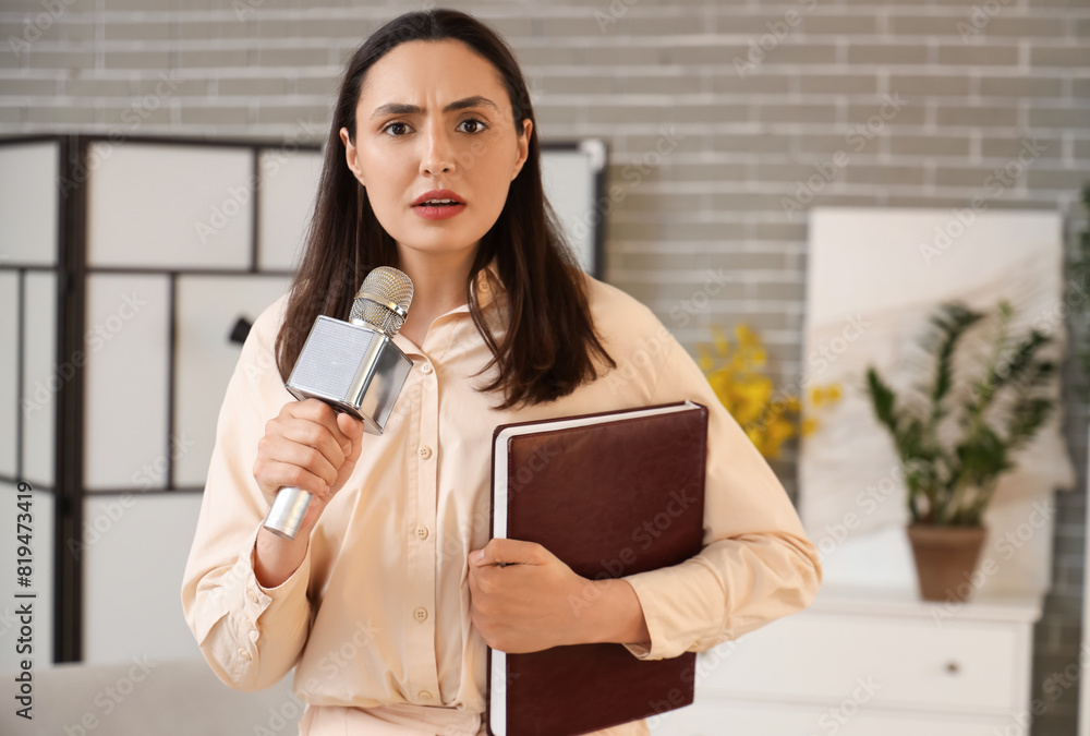 Female reporter with microphone and notebook in studio Female reporter with microphone and notebook in studio