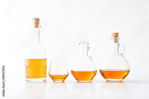 Glass Bottles with Golden Liquid on White Background