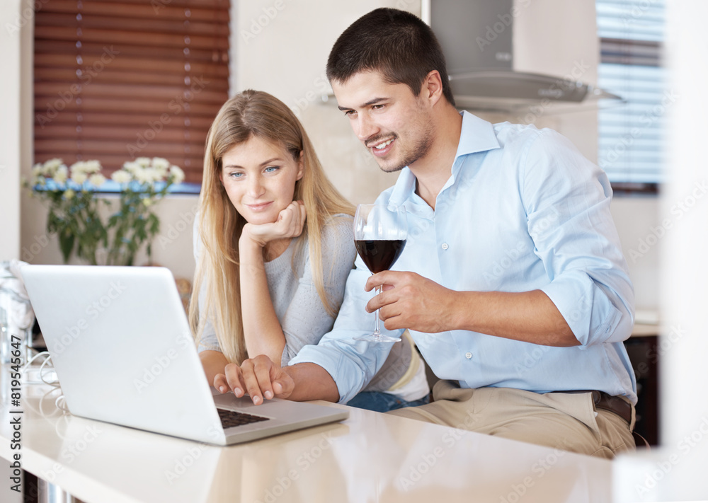 Happy couple, laptop and research with wine glass in kitchen for online shopping, browsing or news at home. Young man and woman with smile on computer for checking renovation or dinner date at house Happy couple, laptop and research with wine glass in kitchen for online shopping, browsing or news at home. Young man and woman with smile on computer for checking renovation or dinner date at house