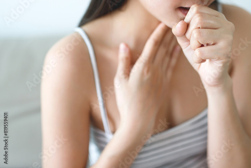 A woman has a sore throat from the flu and COVID-19.