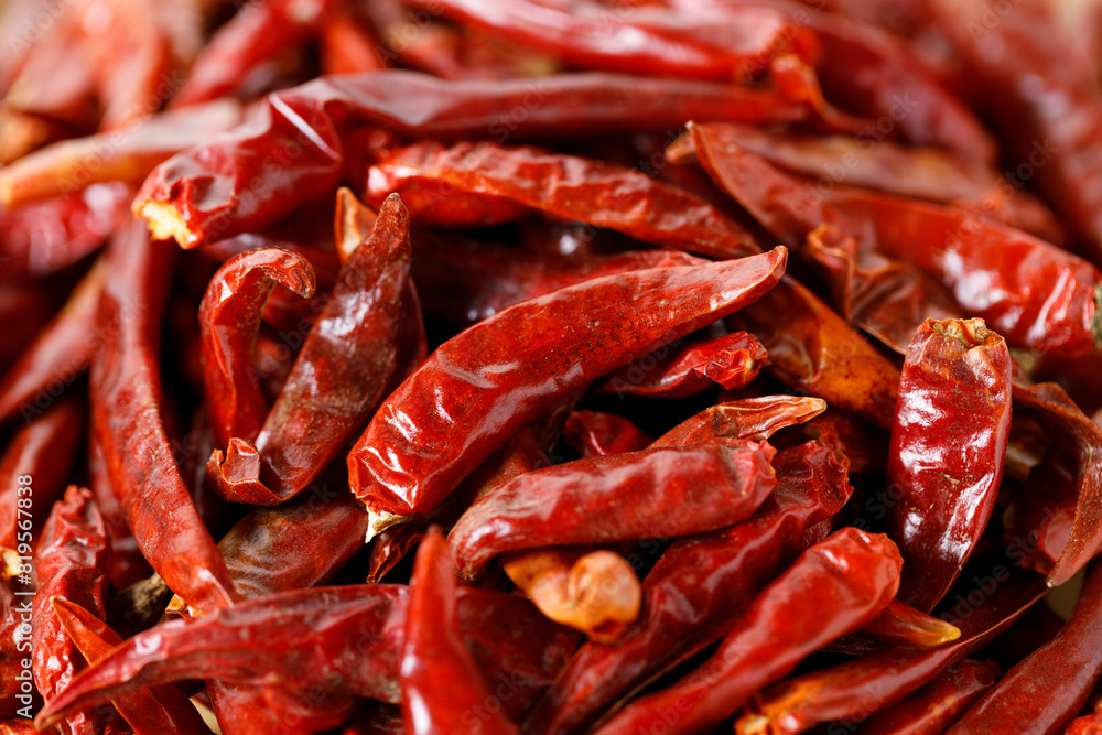 Dried red chilies on wooden tray.