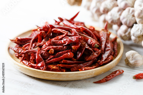 Dried red chilie and garlic on wooden tray.