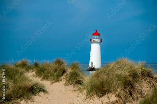 The sand dunes  and the grade II listed building Point of Ayr Lighthouse at Talacre beach in Wales on a sunny summer day.