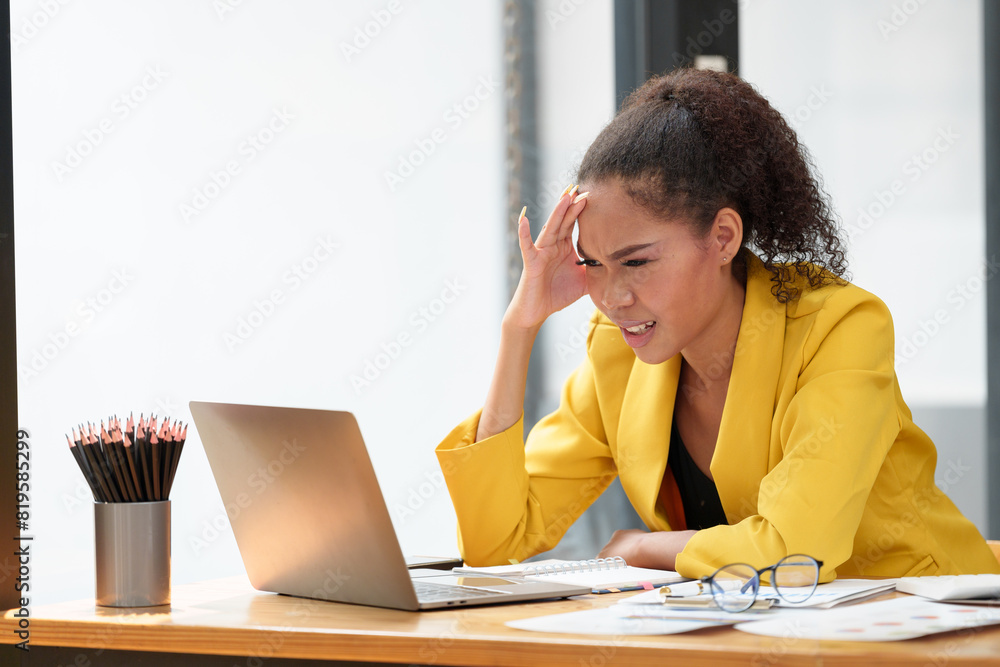 African office worker American working with laptop Tired financial documents having a headache at the office, feeling sick, migraine, feeling pressured, stressed, fatigue, office syndrome concept. African office worker American working with laptop Tired financial documents having a headache at the office, feeling sick, migraine, feeling pressured, stressed, fatigue, office syndrome concept.