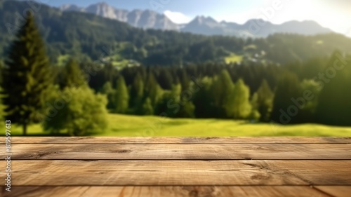 Wooden surface with blurred alpine meadow and mountain background. Smooth and brown wooden table surrounded with peaceful countryside view with green grass, mountain and blue sky. Rural area. AIG35.