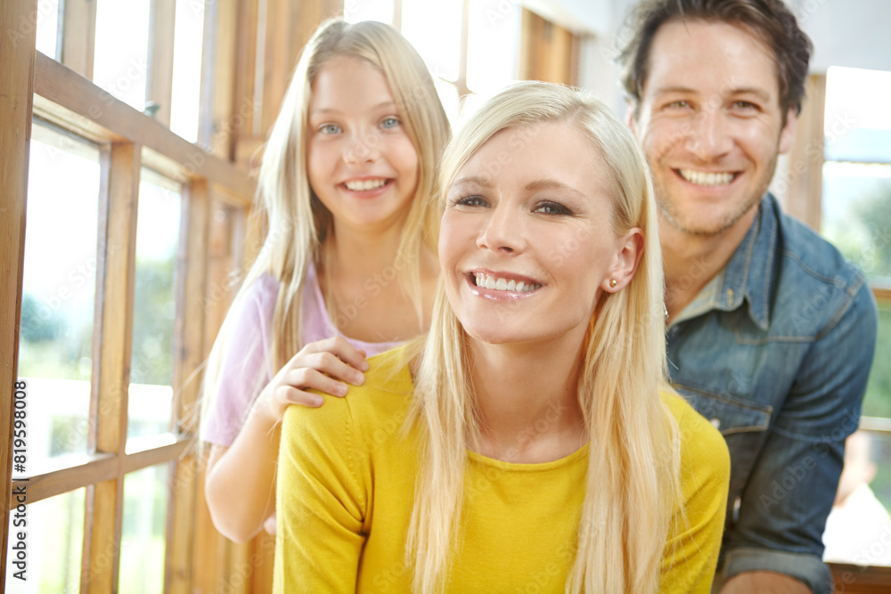 Happy family, portrait and relax with window for bonding, holiday or weekend together at home. Mother, father and young daughter with smile or hug for love, care or embrace in living room at house Happy family, portrait and relax with window for bonding, holiday or weekend together at home. Mother, father and young daughter with smile or hug for love, care or embrace in living room at house