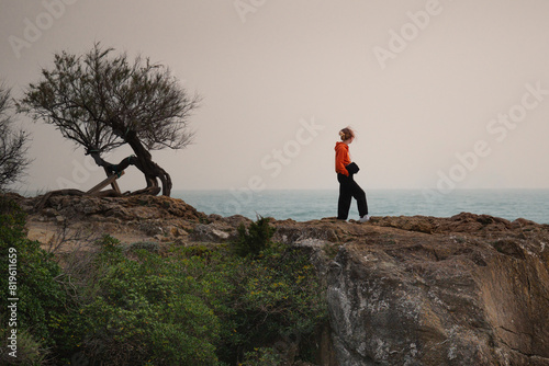 Girl standing on the Cliffs admiring the open Sea, Contemplative Solitude © GioRez