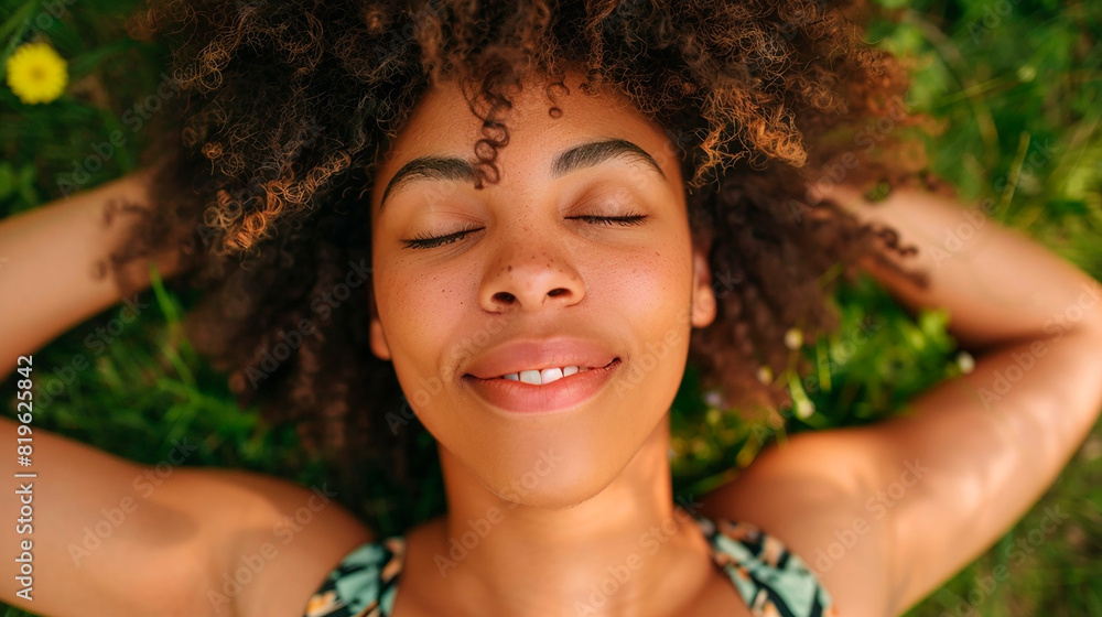 Young woman lying on grass with eyes closed, smiling and relaxed Young woman lying on grass with eyes closed, smiling and relaxed