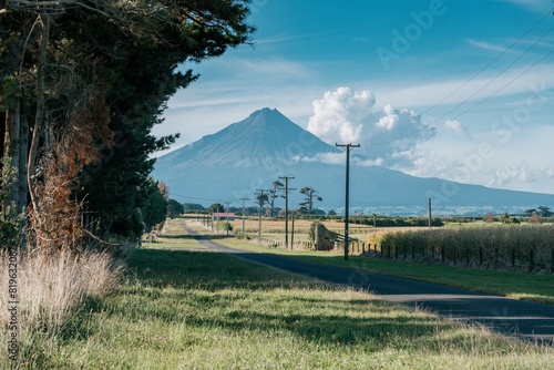 Country road, farmland and the volcano of Mt Taranaki, Taranaki, New Zealand. photo