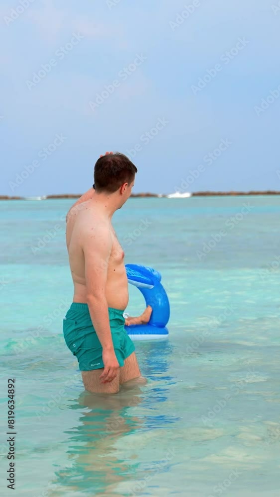 Joke. The father pushes the child out on the swimming circle and waves at him and leaves. A fun imitation of wires into the adult life of a small child Vertical Shot.