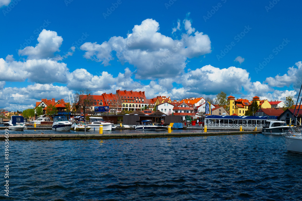Obraz premium 2023-04-28; Lake of town, marina for yachts and boats at the waterfront. Mikolajki, Poland.