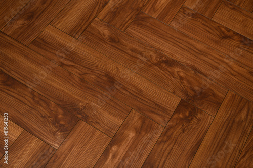 Drewniany ciemnobrązowy parkiet na podłodze z bliska,  przeplatany na ukos photo