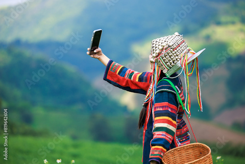 asian woman wearing  traditional dress with hat and basket standing selfie in tea plantation 101, at Chiangrai Province, Thailand photo