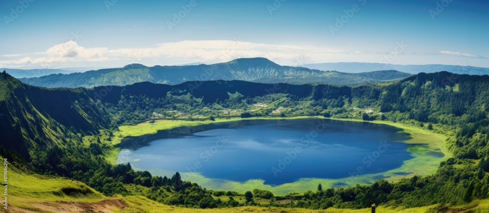 Obraz premium Summer scenery of a volcanic crater lake with a clear blue sky and lush green surroundings ideal for a copy space image