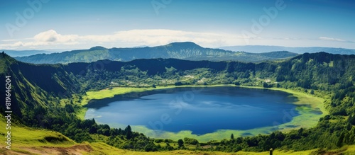 Summer scenery of a volcanic crater lake with a clear blue sky and lush green surroundings ideal for a copy space image
