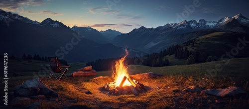 An evening outdoors in the mountains with a campfire surrounded by nature is captured in this scenic copy space image photo