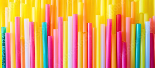 Colorful plastic straws for juice arranged abstractly with a vibrant mix of yellow green and pink creating an interesting copy space image photo