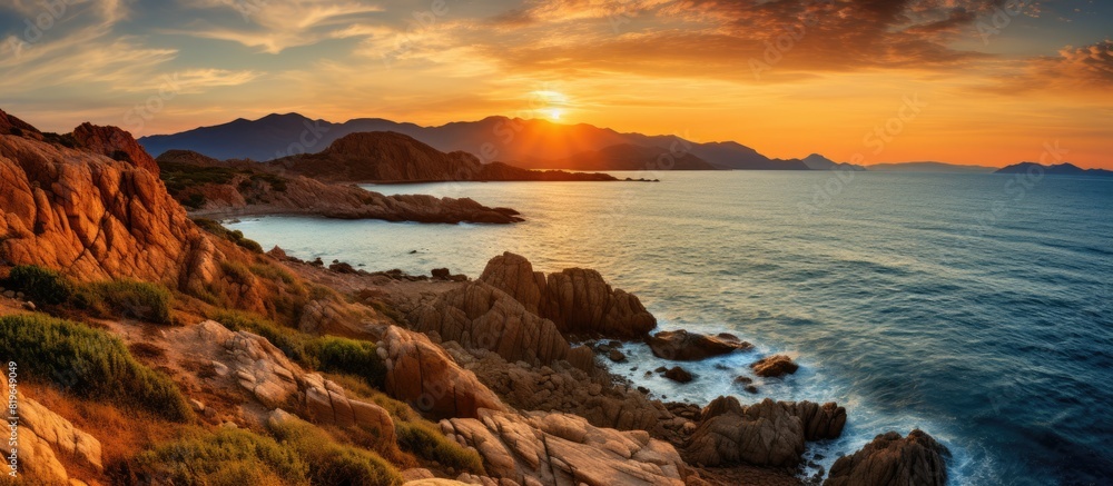 Obraz premium Vibrant sunset over a rugged Sardinian coast featuring ample copy space image
