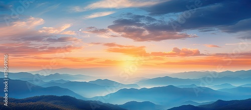 Scenic sunset sky over mountains with orange and blue hues offers a beautiful nature background ideal for a photo with copy space image
