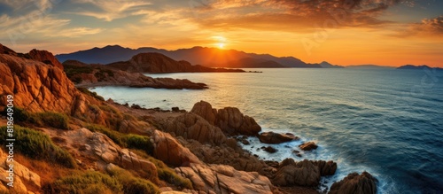 Vibrant sunset over a rugged Sardinian coast featuring ample copy space image