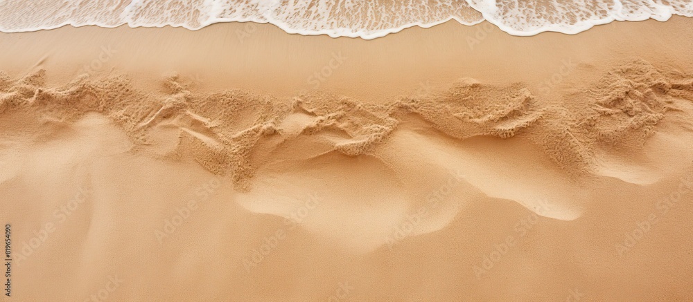 Obraz premium Top view of a sandy beach with visible sand texture ideal as a backdrop for mockups advertising or any design projects requiring a copy space image