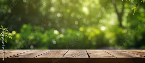 A wooden table with an unoccupied surface is set against a blurred curtain revealing a backdrop of a lush garden with green trees suitable for showcasing products or design layouts that require a copy photo