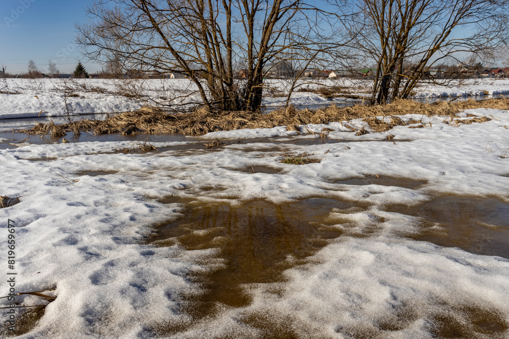 Early spring, melting snow, under the bright rays of the sun, thawed patches in the snow, colorful winter landscape Early spring, melting snow, under the bright rays of the sun, thawed patches in the snow, colorful winter landscape