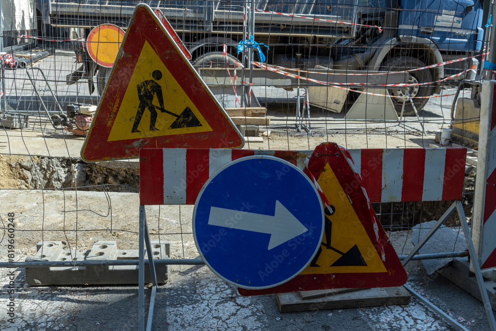 Road construction site with various traffic signs indicating caution ...