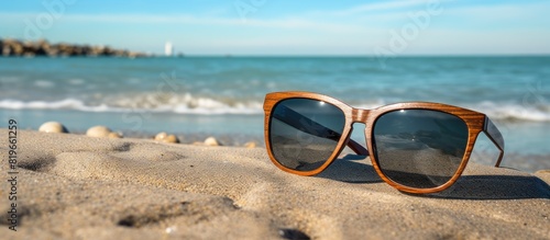 Sunglasses made of wood resting on the beach with a copy space image photo