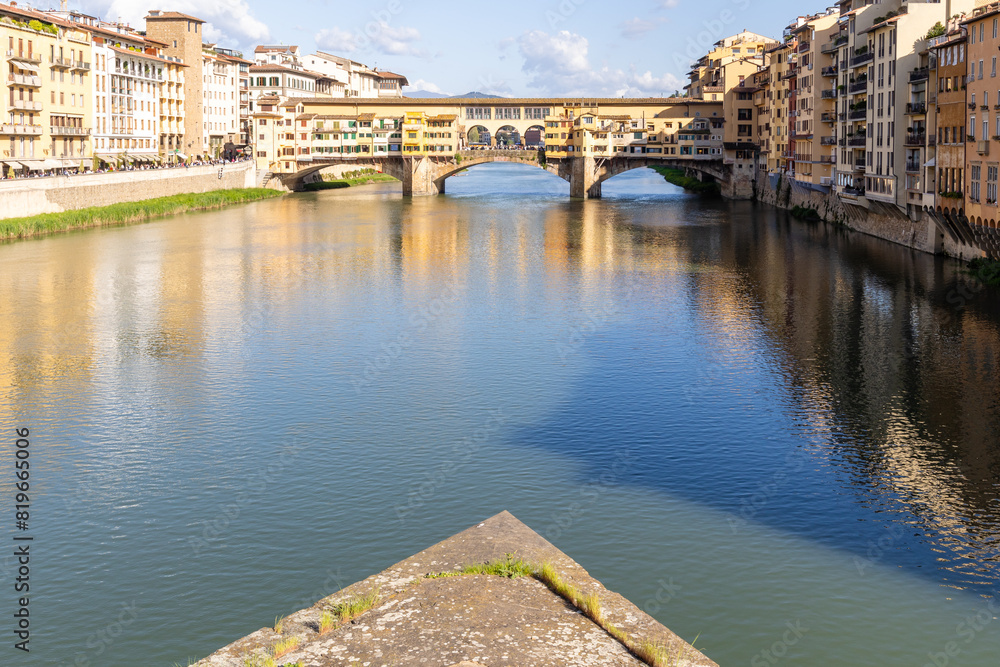 Fototapeta premium Florence, Italy - April 10, 2024: View of the Vecchio Bridge in Florence with tourists crowding its surroundings in Florence, Italy