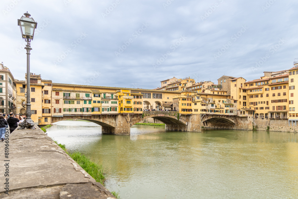 Florence, Italy - April 10, 2024: View of the Vecchio Bridge in Florence with tourists crowding its surroundings in Florence, Italy Florence, Italy - April 10, 2024: View of the Vecchio Bridge in Florence with tourists crowding its surroundings in Florence, Italy