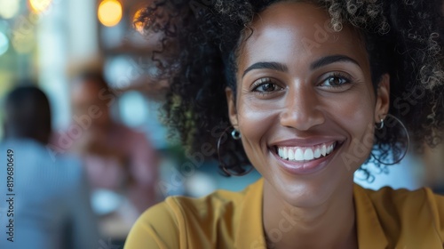 Close-up shot of a person smiling while discussing work-related matters with colleagues during a video conference.