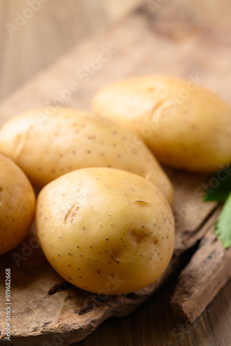 Raw potatoes on wooden background  Food ingredient
