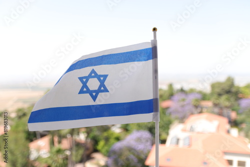 The Israeli flag flutters in the wind over the Jezreel Valley photo