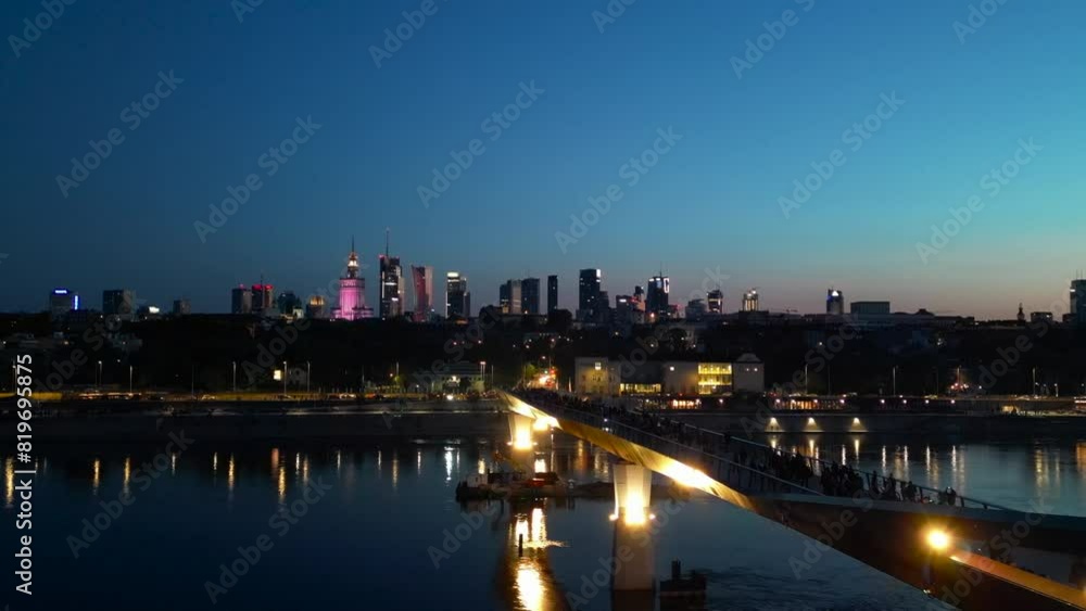 newly built pedestrian and bicycle modern bridge over Vistula river at night, illuminated contemporary architecture of Warsaw, aerial top view 4k newly built pedestrian and bicycle modern bridge over Vistula river at night, illuminated contemporary architecture of Warsaw, aerial top view 4k