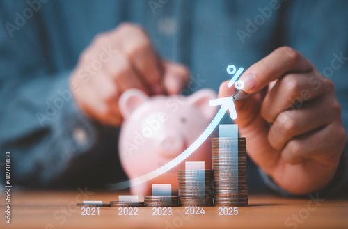 Businessman hand drawing virtual increasing graph with money coins stacking , Business investment profit and deposit dividend saving growth in 2025 concept.